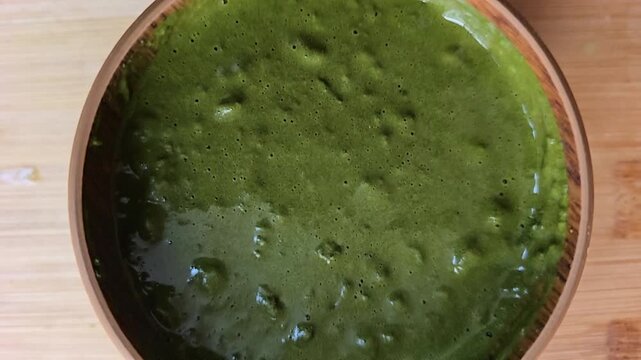 Top view of a freshly mixed, thick Sidr (Ziziphus spina-christi) herbal paste in a wooden bowl. Perfect for showcasing natural cosmetic texture and organic skincare preparation process.