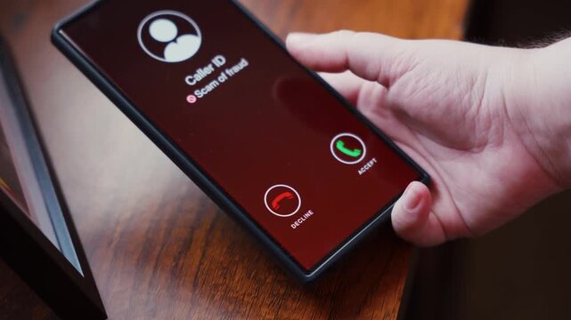 Scam Call Warning on Smartphone Screen Lying on Wooden Table. Phone scams, fraud awareness, digital security threats, and consumer protection.