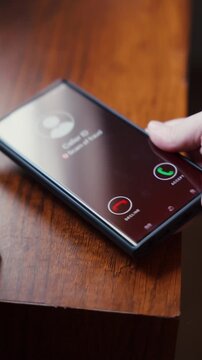 Scam Call Warning on Smartphone Screen Lying on Wooden Table. Phone scams, fraud awareness, digital security threats, and consumer protection.