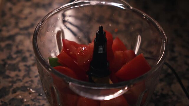 Chopped tomatoes in food processor for traditional Spanish gazpacho preparation. Spanish cuisine and healthy summer food.