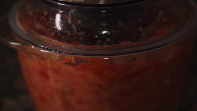 Tomato mixture blending in food processor for gazpacho recipe close up. Spanish cuisine and healthy summer food concept.