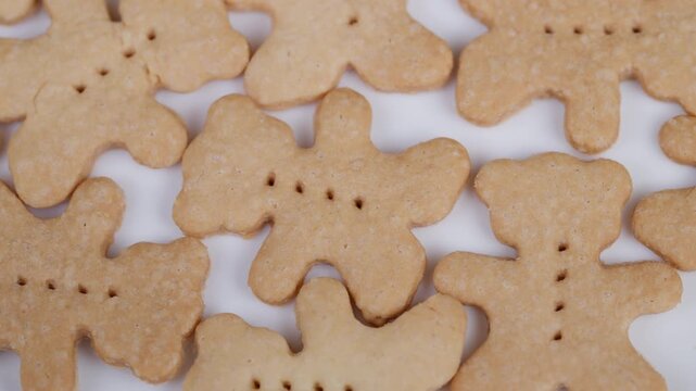 Homemade bear cookies. Cookies arranged on white background. Bearshaped cookies with textured surface. Goldenbrown Shortbread cookies with perforated design scattered around