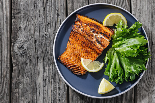 Baked salmon entree with lemon on a plate