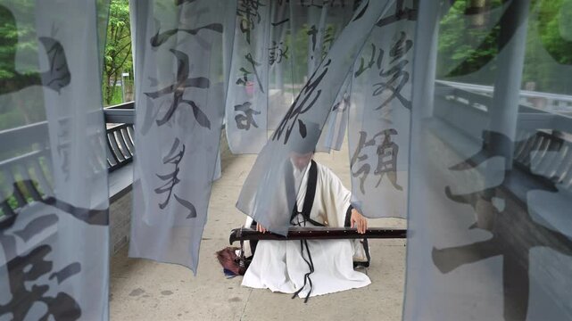 Ancient Chinese Literati Playing Guqin With Traditional Ink Calligraphy Background, Elegant Wei Jin Style Oriental Zen ArtSerene Oriental Scene: Hanfu Scholar Plays Classical Guqin Surrounded by China