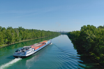 Fototapeta premium Péniche de marchandises transportant des conteneurs sur le Rhône en France direction Lyon.