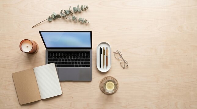 Modern home office desk flat lay with laptop notebook and eucalyptus on wood with copy space
