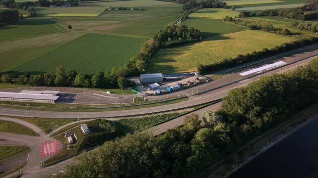 Drone footage of an automotive development center in Germany featuring endurance testing loops, braking tracks and rural surroundings near Ismaninger Speichersee