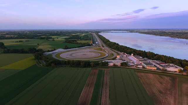 High angle drone shot of a vehicle development center in Germany showing structured test tracks and engineering infrastructure in a rural landscape
