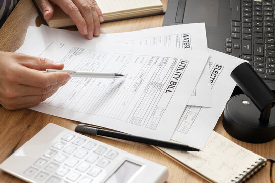 Woman reviewing household bills and calculating energy, water costs