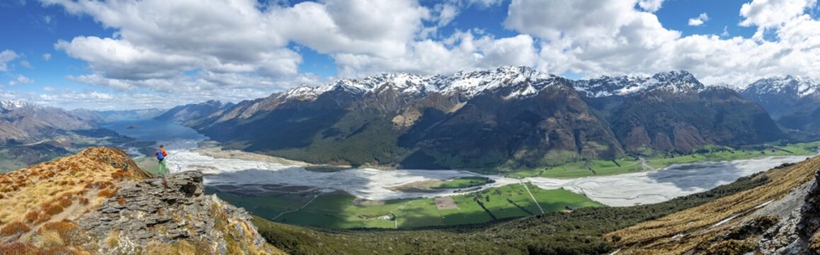 Hiker on the summit of Mount Alfred, views of Lake Wakatipu and Dart River with mountain scenery, Glenorchy near Queenstown, Southern Alps, Otago, South Island, New Zealand