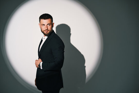 Handsome businessman in black suit under spotlight