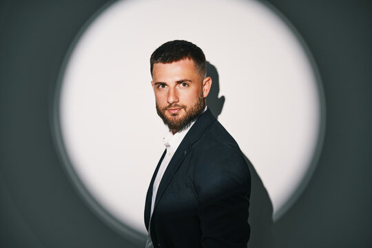 Elegant businessman in black suit under spotlight
