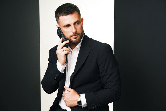 Handsome man in black suit talking on phone