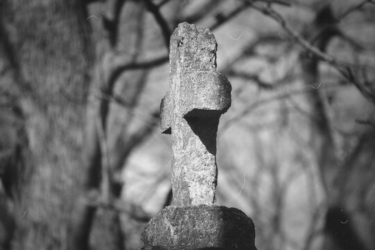 An Old Weathered Stone Cross Standing in a Quiet Historic Cemetery Setting