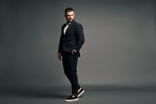 Handsome man in black suit full length portrait