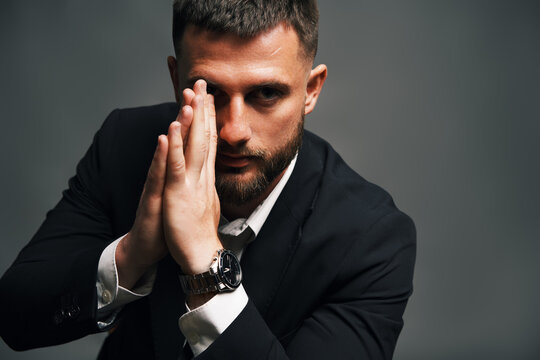 Handsome confident man in black suit on chair