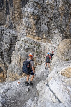 Three hikers on the Via Ferrate Benini via ferrata on a cliff, Brenta Mountains, Parco Naturale Brenta-Adamello, Trentino, Italy