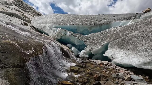 Glacial Meltwater Cascade Flowing Near Blue Ice Serac Wall at Aletsch Glacier Valais Switzerland