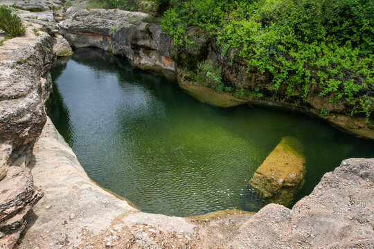 Charca del Molino (natural limestone pool) on sunny day. Arnes, Tarragona, Spain.
