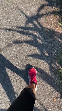 donna che cammina sulla strada con scarpe rosa