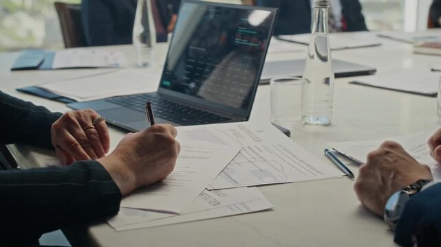Handheld shot of Caucasian businessman handing over oil transportation contract to colleague during corporate meeting. Perfect for energy sector B2B marketing and corporate presentations