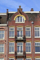 Naklejka premium Amsterdam Marnixstraat Brick House Facade with Yellow Brickwork and Sculpted Cats Decoration, Netherlands