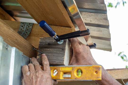Wooden beam fixed with a F-clamp tool during construction