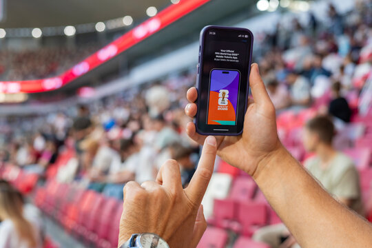 MINSK, BELARUS JUNE 9, 2026: Man holding a purple Apple iPhone 14 Pro in the stadium. The official FIFA mobile application selling tickets for the 2026 FIFA World Cup in the USA, Mexico, Canada