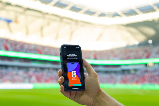 MINSK, BELARUS JUNE 9, 2026: Man holding a purple Apple iPhone 14 Pro in the stadium. The official FIFA mobile application selling tickets for the 2026 FIFA World Cup in the USA, Mexico, Canada.