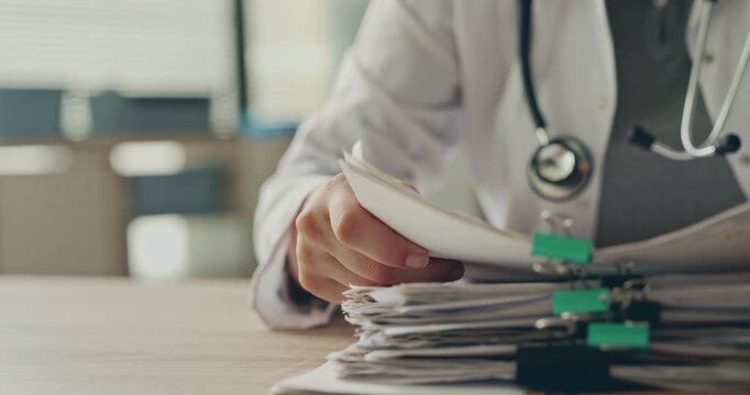 Healthcare personnel reviewing a stack of files