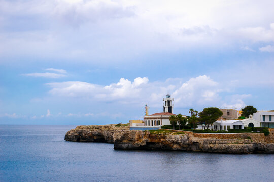 Panoramic view of the colorful Far de Ciutadella Lighthouse perched at the entrance to the port, Menorca, Balearic Islands, Spain