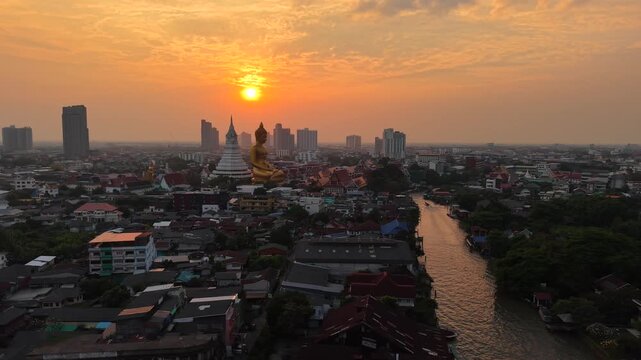 Aerial view Wat paknam bhasicharoen big golden Buddha and a stunning psychedelic meditation hall sunset sky Thonburi Bangkok Thailand