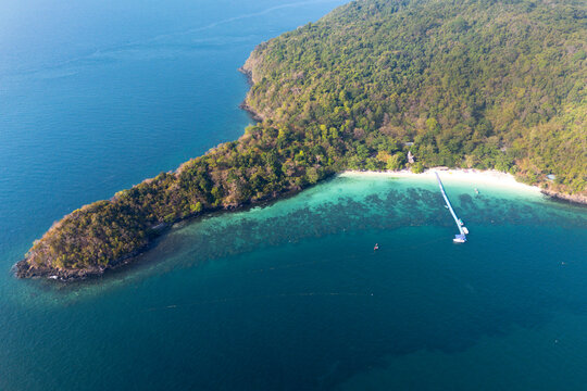 Tropical beach on Ko He Coral Island, Phuket, Thailand. White sand, clear ocean water showing reef