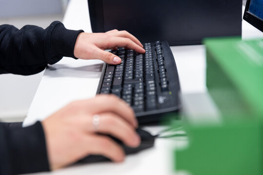 Close-up of a person's hands typing on a backlit mechanical keyboard in a dark environment.