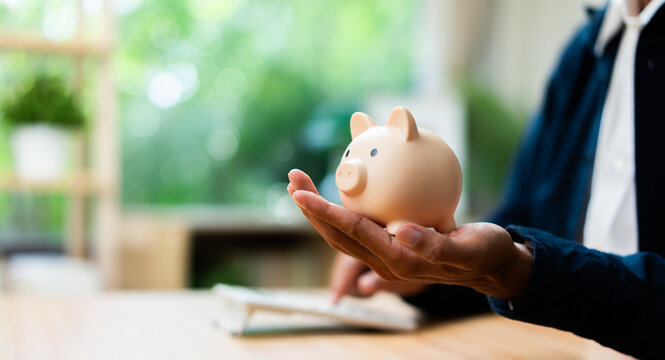 Personal finance and savings concept featuring a piggy bank in hand, financial planning, money management, wealth building, budgeting strategy, investment goals, and long-term financial security.