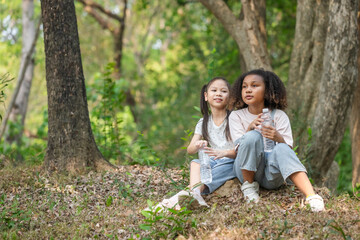 Fototapeta premium Two Children Resting in Forest During Eco Education and Outdoor Nature Exploration