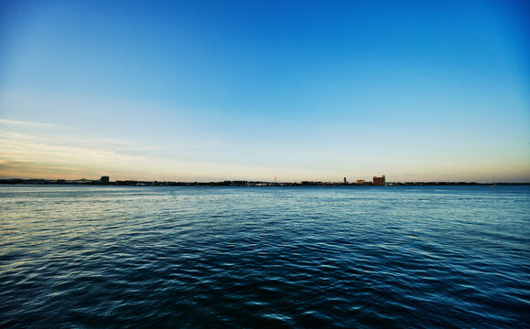 View of the Boston Harbor at dusk as seen from the Boston Seaport district, Massachusetts, New England
