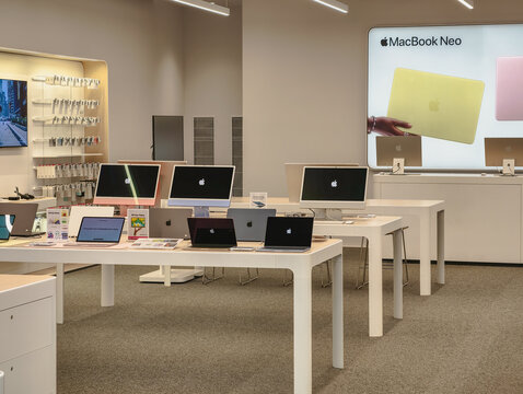 Prague, Czech Republic - June 18, 2026: Interior view of an Apple retail store with computers, laptops and illuminated product displays showcasing consumer electronics, technology retail