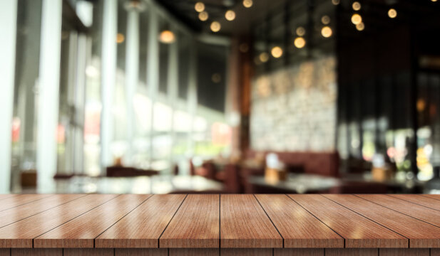 Empty wooden table top with lights bokeh on blur restaurant background.