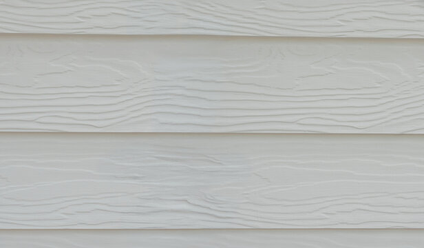 Close-up of white painted wood panel surface showing natural wood grain texture and horizontal plank pattern. Clean minimal background perfect for design, architecture, and construction concepts. 