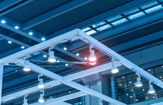 Directional LED lights on rails under the ceiling in a modern warehouse, shopping center building, office or other commercial real estate object.