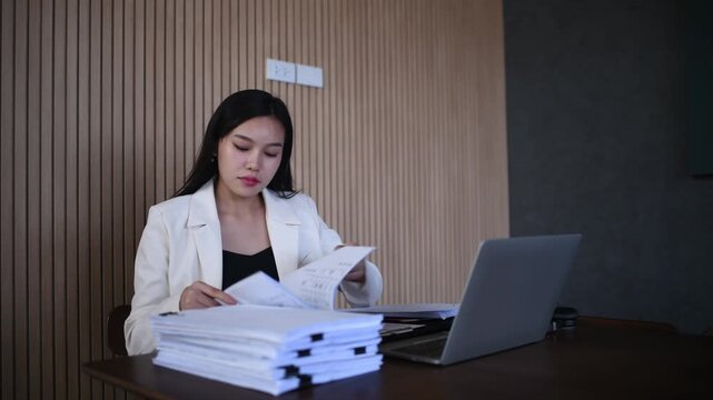 Woman working writing notes in notebook while using a laptop represents business education and professional development concepts of remote work studying and productivity.