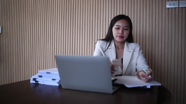 Woman working writing notes in notebook while using a laptop represents business education and professional development concepts of remote work studying and productivity.