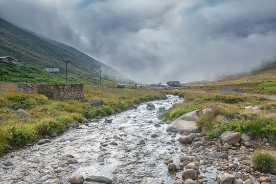 Traditional stone and wooden houses of Trovit Highland under foggy peaks in Kackar Mountains, Rize, Turkey