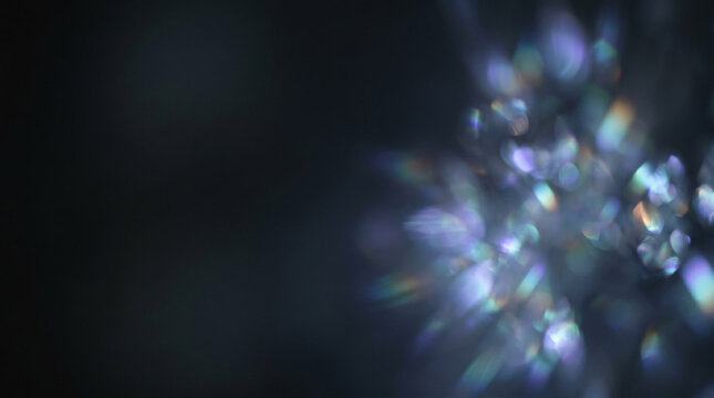 Prism crystal light refraction on dark background.