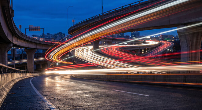 Abstract neon light trails speeding through futuristic city highway