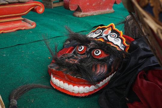 Traditional Indonesian Barongan mask resting beside gamelan instruments on a performance stage, representing Javanese cultural heritage and traditional arts