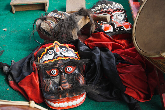 Traditional Indonesian Barongan mask resting beside gamelan instruments on a performance stage, representing Javanese cultural heritage and traditional arts