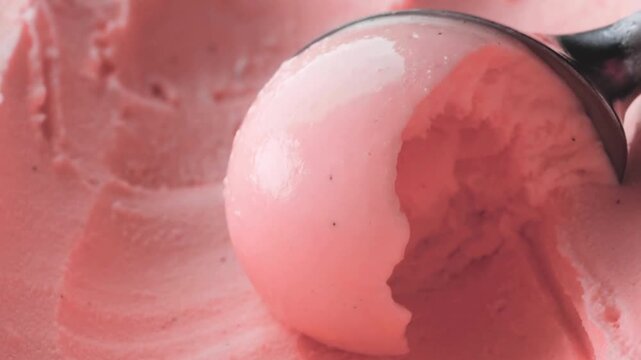 Strawberry pink ice cream being scooped, creamy fruit sorbet texture close up, metal scoop serving delicious frozen gelato dessert