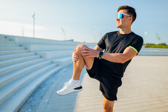 Running preparation at sunset, athlete stretching knee in a beautiful outdoor space
